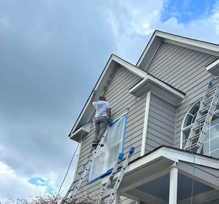 Gonzales Painters working on the exterior painting of a house.